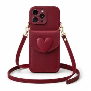 Op de afbeelding: Bordeaux telefoonhoesje met een hartvormig accent op de voorzak. De hoes heeft een bijpassende bordeauxrode band en goudkleurige hardware. De telefoonhoes is ontworpen om een smartphone te bevatten en heeft een crossbody band.