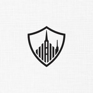 Könnte beinhalten: Ein schwarzes grafisches Logo-Design in Schildform, das eine stilisierte Darstellung eines Wolkenkratzers mit vertikalen Linien und einer zentralen Turmspitze enthält, vor einem weißen Hintergrund mit feiner Textur.