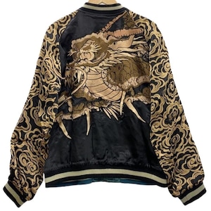 Peut inclure: Un blouson bomber en satin noir orné d'un grand dragon brodé en fils dorés et beiges dans le dos. Les manches et les panneaux arrière présentent un motif répétitif de nuages dorés. Le blouson possède un col, des poignets et un ourlet côtelés.