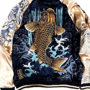 Könnte beinhalten: Eine marineblaue und champagnerfarbene Satin-Bomberjacke mit aufwendiger Stickerei eines großen goldenen Koi-Karpfens, der durch blaue Wellen und einen Wasserfall schwimmt. Die Ärmel sind champagnerfarben mit Wellenmustern und gerippten Bündchen.