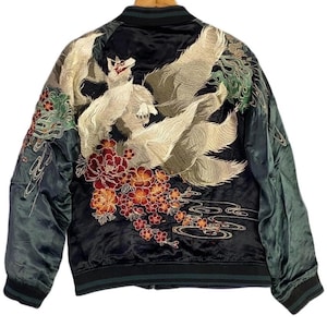 May include: A black satin bomber jacket featuring intricate embroidery on the back. The design depicts a multi-tailed fox surrounded by red and orange peony flowers, green foliage, and stylised water waves. The jacket has dark ribbed cuffs and collar.
