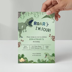 Może przedstawiać: Jasnozielone zaproszenie urodzinowe z motywem dinozaurów. Zaproszenie brzmi "ROAR I'M FOUR!" i zawiera szczegóły dotyczące 4. urodzin Jonathana. Projekt zawiera ilustracje dinozaurów i informacje o wydarzeniu.