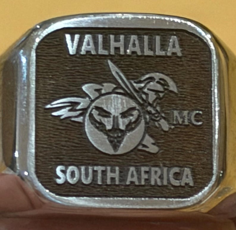 Rectangular metal tag reading VALHALLA SOUTH AFRICA with winged helmet, satin finish, coin engraving files sample.