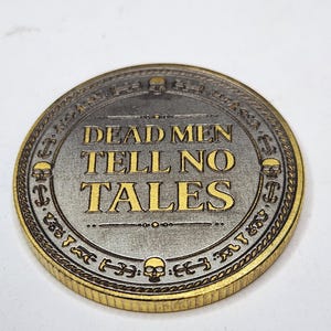 Ornate coin with dense gothic lettering and raised border, used in a laser test matrix for fine detail checks.