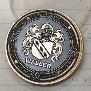 Heraldic challenge coin with coat of arms and WALLER text, crisp contrast showcasing metal engraving settings.