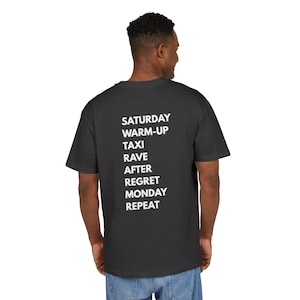 Puede incluir: Una camiseta gris oscuro con texto blanco en la espalda. El texto enumera una secuencia de actividades: Sábado, Calentamiento, Taxi, Rave, Después, Arrepentimiento, Lunes, Repetir. La camiseta es una prenda informal.