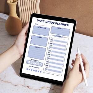 Könnte beinhalten: Ein digitales Tablet mit einer Vorlage für einen "Täglichen Studienplaner". Der Planer enthält Abschnitte für tägliche Inspiration, Lernziele, Erinnerungen, eine To-Do-Liste, einen Stimmungstracker und einen Wassertracker. Das Design ist blau und weiß.