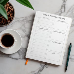 Könnte beinhalten: Ein weißer Produktivitäts-Dashboard-Planer mit schwarzem Text, der Abschnitte für Top 3 Ziele, Prioritäten, Erfolgsmetriken, Fokus des Monats, Erfolge des Monats und Notizen enthält. Der Planer hat ein kleines orangefarbenes Lesezeichenband.