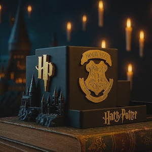 May include: Black and gold Harry Potter-themed bookends featuring the Hogwarts crest and the HP logo. The bookends are displayed on a stack of books with a castle silhouette and the words "Harry Potter". Floating candles are in the background.
