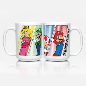 Op de afbeelding: Witte keramische mok met Super Mario-personages Prinses Peach, Luigi, Toad en Mario. De mok heeft een grote handgreep en het woord "Super Mario" in een diagonale streep. De personages staan tegen kleurrijke gestreepte achtergronden.