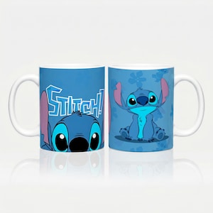 Puede incluir: Una taza de cerámica azul con un gráfico del personaje Stitch de Lilo & Stitch. Un lado muestra la cara del personaje con el texto "STITCH!" en una fuente estilizada, mientras que el otro lado muestra al personaje completo sentado.