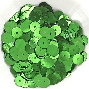May include: A large pile of green, round sequins. The sequins are shiny and have a metallic finish.