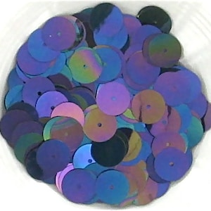 May include: A pile of iridescent sequins in shades of blue, purple, and pink. The sequins are round and have a metallic sheen.