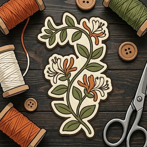 May include: A die-cut sticker featuring a honeysuckle vine with green leaves and orange and white flowers. The sticker is surrounded by sewing supplies including four wooden spools of thread in orange, white, and green, two wooden buttons, and scissors.