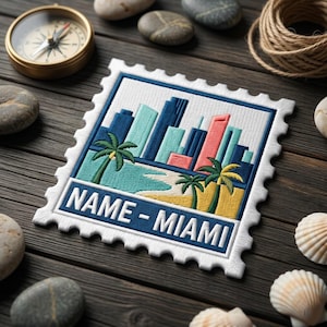 May include: Embroidered patch in the shape of a postage stamp featuring a Miami skyline with palm trees and a beach. The patch has a white border and the text "NAME - MIAMI" in a blue banner.