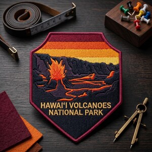 May include: A pentagonal embroidered patch featuring a volcanic landscape with orange lava flows, a dark mountain range, and a sunset sky. The text HAWAI'I VOLCANOES NATIONAL PARK is stitched in yellow at the bottom. The patch has a dark red border.