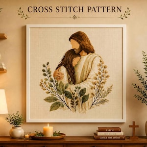 May include: A square framed cross stitch pattern featuring a depiction of a person with long brown hair embracing another person with long brown hair, surrounded by green foliage. The text CROSS STITCH PATTERN is printed above the image.