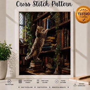May include: A cross stitch pattern featuring a tabby cat standing on a stack of books in a library, reaching for a shelf. The image includes text reading Cross Stitch Pattern and a gold seal stating TESTED PATTERN with a checkmark symbol.