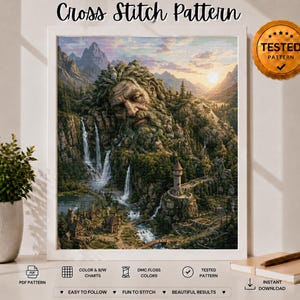 Könnte beinhalten: Ein Kreuzstichmuster mit einer Landschaft, die ein riesiges, aus Bergen geformtes Steingesicht, Wasserfälle, einen Steinturm und ein kleines Dorf zeigt. Das Bild enthält den Text Cross Stitch Pattern und ein goldenes Siegel TESTED PATTERN.