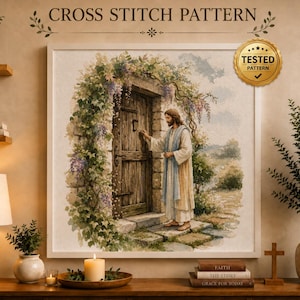 Puede incluir: Un patrón de punto de cruz enmarcado que muestra una figura con túnica ante una puerta de madera rodeada de enredaderas y flores moradas. La imagen incluye el texto CROSS STITCH PATTERN y un sello dorado con el texto TESTED PATTERN.
