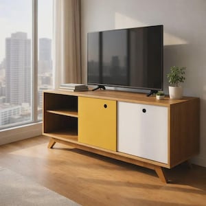 以下が含まれることがあります： 明るい木目調のミッドセンチュリーモダンなテレビ台。黄色と白のスライドドアが特徴です。斜めの脚と棚があります。黒い薄型テレビが上にあり、小さな植物と本が置かれています。