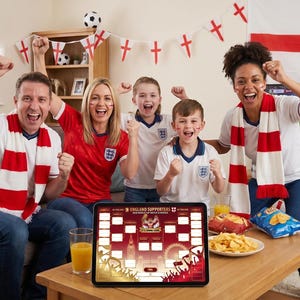 Può includere: Un tablet digitale che mostra un grafico del torneo England Supporters è appoggiato su un tavolino in legno. Lo schermo presenta il testo England Supporters, uno stemma centrale e campi vuoti su uno sfondo rosso e bianco.
