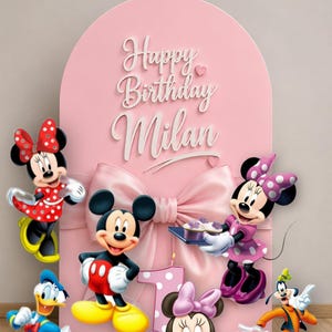 Pu&ograve; includere: Uno sfondo ad arco rosa con un grande fiocco centrale e la scritta bianca Happy Birthday Milan. Attorno allo sfondo ci sono sagome di Topolino, Minnie, Paperino, Pippo e una candelina rosa a forma di numero uno con base Minnie.