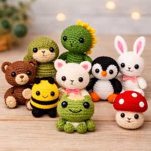 May include: A collection of handmade crochet amigurumi toys, including a brown bear, a green dinosaur, a white bunny with pink ears, a black and white penguin, a yellow and black bee, a white bear with a pink bow, a green frog, and a red mushroom.
