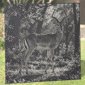 May include: A square black panel featuring a pointillist design created with numerous small white dots. The pattern forms the silhouette of a large animal, likely an elephant, standing in profile against a dark background.
