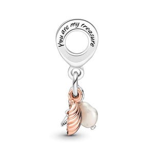 Puede incluir: Un charm de plata con la inscripción "You are my treasure". Debajo, una concha de color oro rosa y una perla blanca cuelgan del charm. El charm está diseñado para una pulsera o collar.