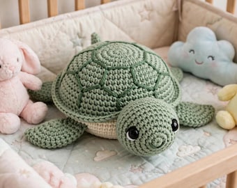 May include: A crocheted sea turtle plush toy with a sage green shell and a cream-colored underside, featuring large black safety eyes. It is positioned between a light pink plush rabbit, a light blue plush cloud, and a yellow plush duck.