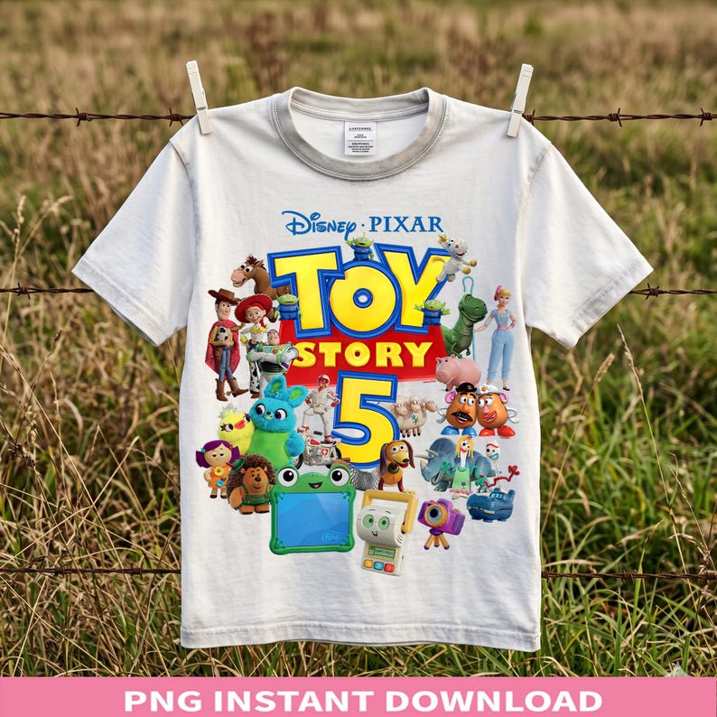May include: A white short-sleeved t-shirt featuring a colorful graphic print of various Toy Story characters surrounding the large yellow and blue text Toy Story 5. The design includes Woody, Buzz Lightyear, Jessie, and other animated figures.