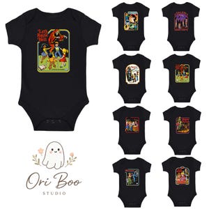 Puede incluir: Bodys de bebé negros con varios diseños gráficos retro. Uno presenta el texto "Let's Raise Hell" con una ilustración vintage. Otros diseños incluyen escenas con figuras y texto. El logotipo de Ori Boo Studio está en la parte inferior.