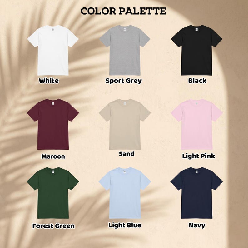 May include: A color palette of t-shirts in various colors, including white, sport grey, black, maroon, sand, light pink, forest green, light blue, and navy. Each shirt is displayed on a neutral background, with the color name labeled below.