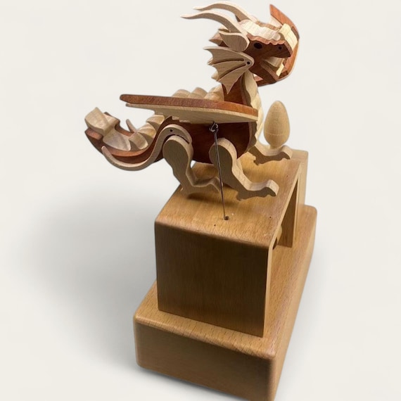 A hand-crafted beech wood dragon automaton that flaps its wings and plays 32 melodies — kinetic sculpture meets music box in one jaw-dropping desk piece.