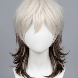 May include: A two-toned wig with a layered, shaggy style. The top section is a light, creamy blonde, transitioning to a darker brown at the roots and ends. The wig is displayed on a white mannequin head.