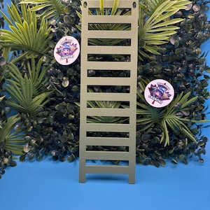 May include: A rectangular olive green ladder with ten horizontal rungs and two circular holes at the top corners. The ladder features a matte finish and is positioned vertically, displaying a uniform structure with evenly spaced rungs throughout.