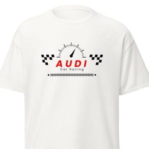 Puede incluir: Camiseta blanca con un diseño de velocímetro, la palabra "AUDI" en rojo y "Car Racing" debajo. El diseño incluye banderas a cuadros en blanco y negro. Un diseño clásico para los aficionados a las carreras de coches.