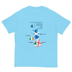 May include: A light blue t-shirt featuring a graphic of the United Kingdom map filled with national flags. The text reads United Kingdom, 4, Capital Cities, Governments, Laws, Cultures, Belfast, Edinburgh, Cardiff, and London with small flag icons.