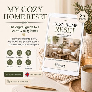 Peut inclure: Un guide numérique intitulé My Cozy Home Reset, comprenant 85 pages d'organisation, de listes de contrôle, de bricolage, de routines et de conseils. La tablette affiche un intérieur de salon avec des instructions pour une maison chaleureuse.