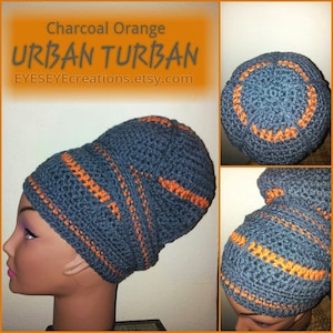 Puede incluir: Un turbante urbano gris carbón con rayas naranjas, tejido a ganchillo. El sombrero se muestra en una cabeza de maniquí. El texto "Charcoal Orange Urban Turban" y una URL de Etsy son visibles.