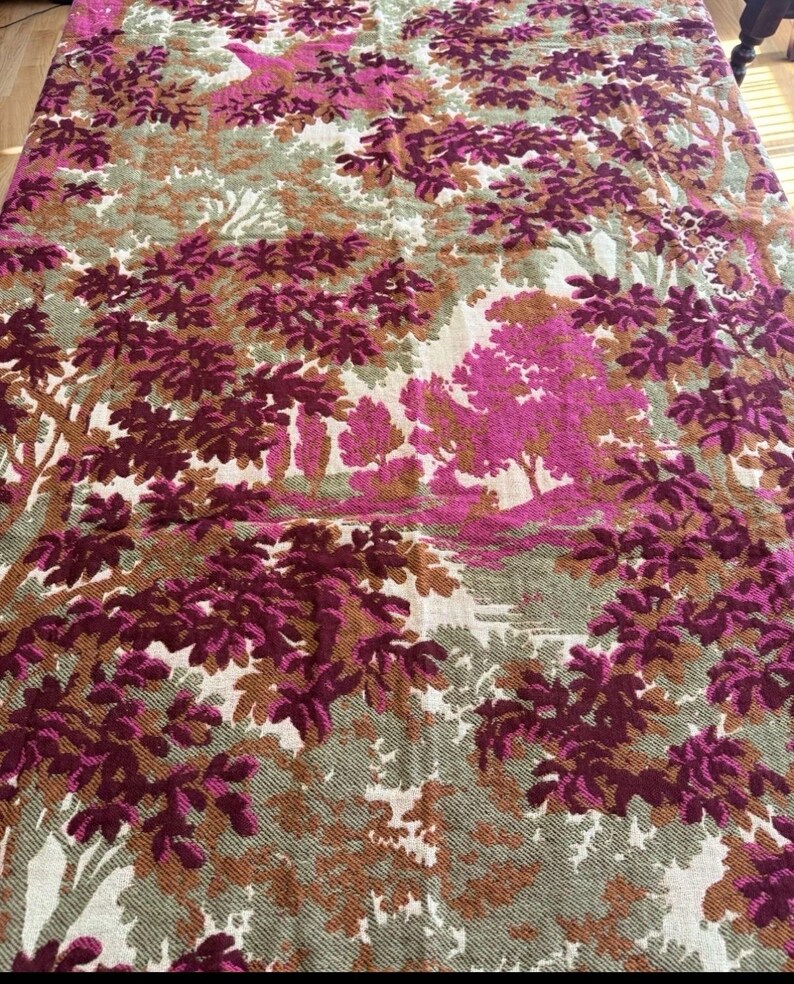 May include: A large textile featuring a forest scene in shades of pink, brown, and green. The design includes stylized trees and foliage, creating a patterned, decorative fabric. The overall aesthetic is vintage and nature-inspired.