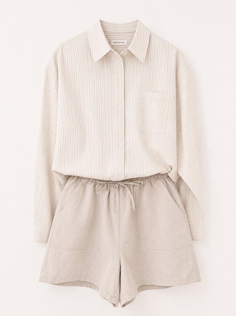 Puede incluir: Una camisa de manga larga abotonada con un patr&oacute;n de rayas verticales en beige y blanco, cuello y bolsillo en el pecho, combinada con pantalones cortos beige con cintura el&aacute;stica, cord&oacute;n ajustable y dos bolsillos delanteros. La etiqueta dice RIVAVIVA.