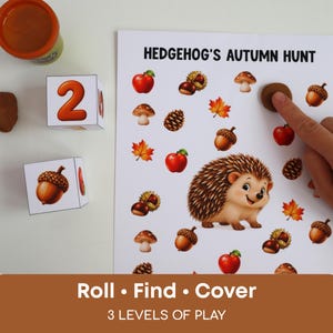 Può includere: Un foglio di attività Hedgehog's Autumn Hunt con un'illustrazione centrale di un riccio circondata da mele, funghi, ghiande e foglie. Include due dadi bianchi con numeri e grafiche naturali, più un contenitore di pasta modellabile marrone.