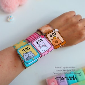 May include: A wrist adorned with three colorful paper watch bands, each featuring a different cartoon animal and time display: a cat at 4:15, a bunny at 2:35, and a bear at 6:07. The bands are decorated with patterns and the text "This is a Digital Product - Please Read the Full Description Before Purchase katemade."