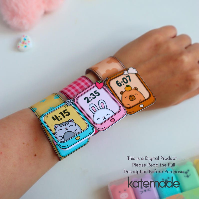 May include: A wrist adorned with three colorful paper watch bands, each featuring a different cartoon animal and time display: a cat at 4:15, a bunny at 2:35, and a bear at 6:07. The bands are decorated with patterns and the text "This is a Digital Product - Please Read the Full Description Before Purchase katemade."