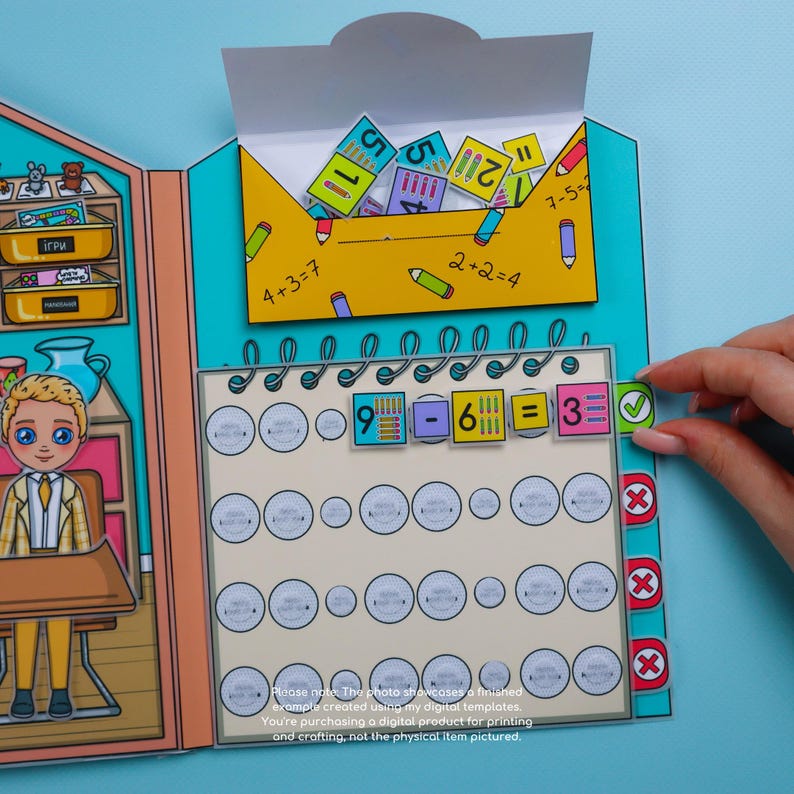 May include: A colorful paper math learning toy with a classroom theme. The toy features a subtraction problem with the answer 3. The image includes the text "4+3=7" and "2+2=4".