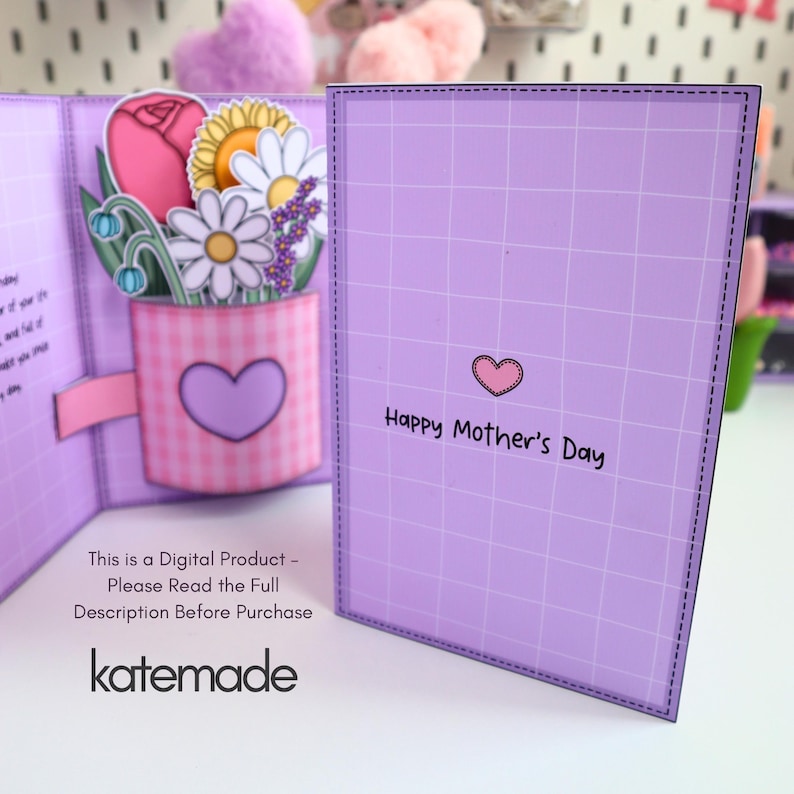 May include: A handmade Mother's Day card with a pop-up floral arrangement. The card features a pink gingham vase with a purple heart, holding paper flowers. The card is lavender with a grid pattern and the text "Happy Mother's Day".