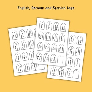 May include: Three sheets of white paper featuring rows of rectangular gift tags with rounded top corners and pre-punched holes. Each tag contains black printed text in English, German, and Spanish, including phrases like Thank you, Danke, and Con cari&ntilde;o.
