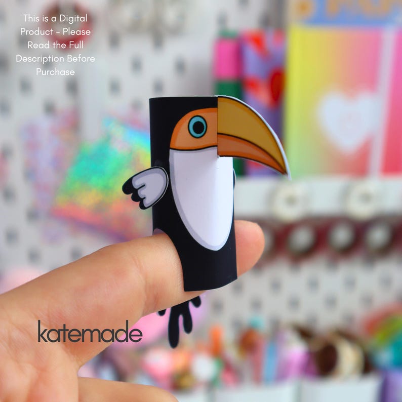 May include: A paper toucan finger puppet featuring a black body, white chest, and a large orange beak. The text "This is a Digital Product - Please Read the Full Description Before Purchase" is visible at the top, and "katemade" is at the bottom.